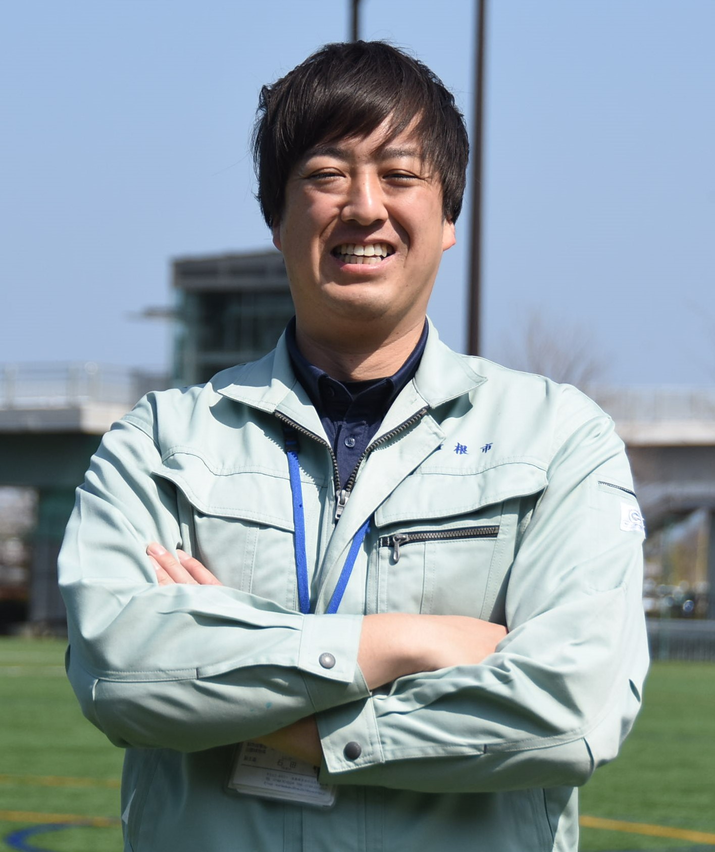 公園で腕を組む笑顔の石田さんの写真