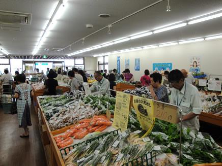 複数の客が店内の商品野菜を見ている写真