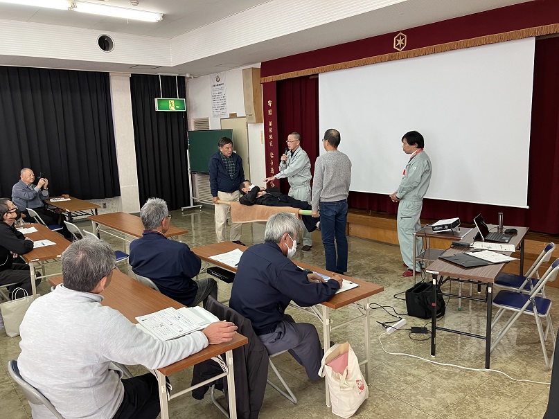 搬送法（応急担架）の講習を受ける参加者達