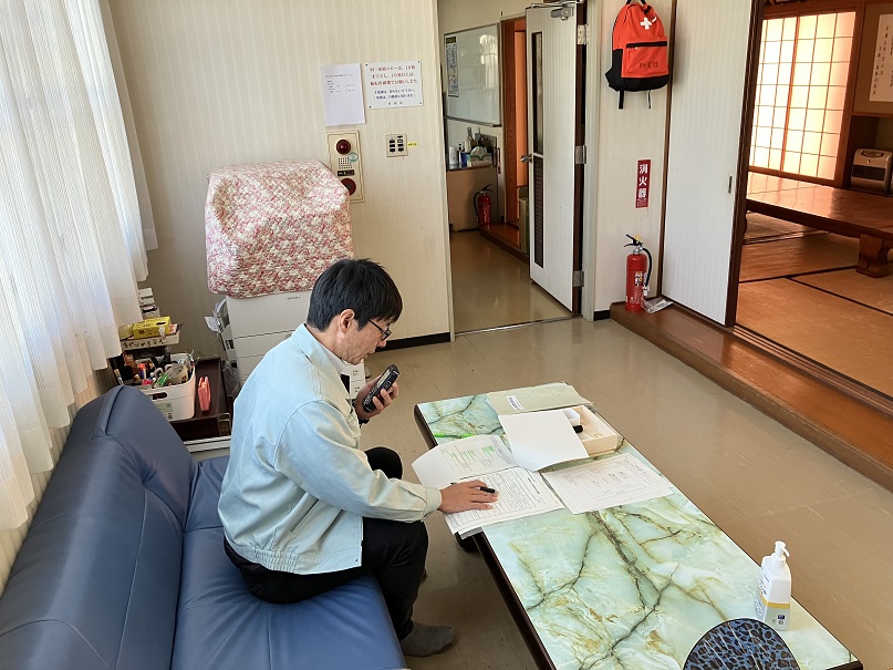 書類を前に無線機で話す男性