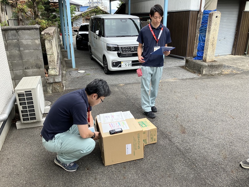 屋外で書類を確認する職員