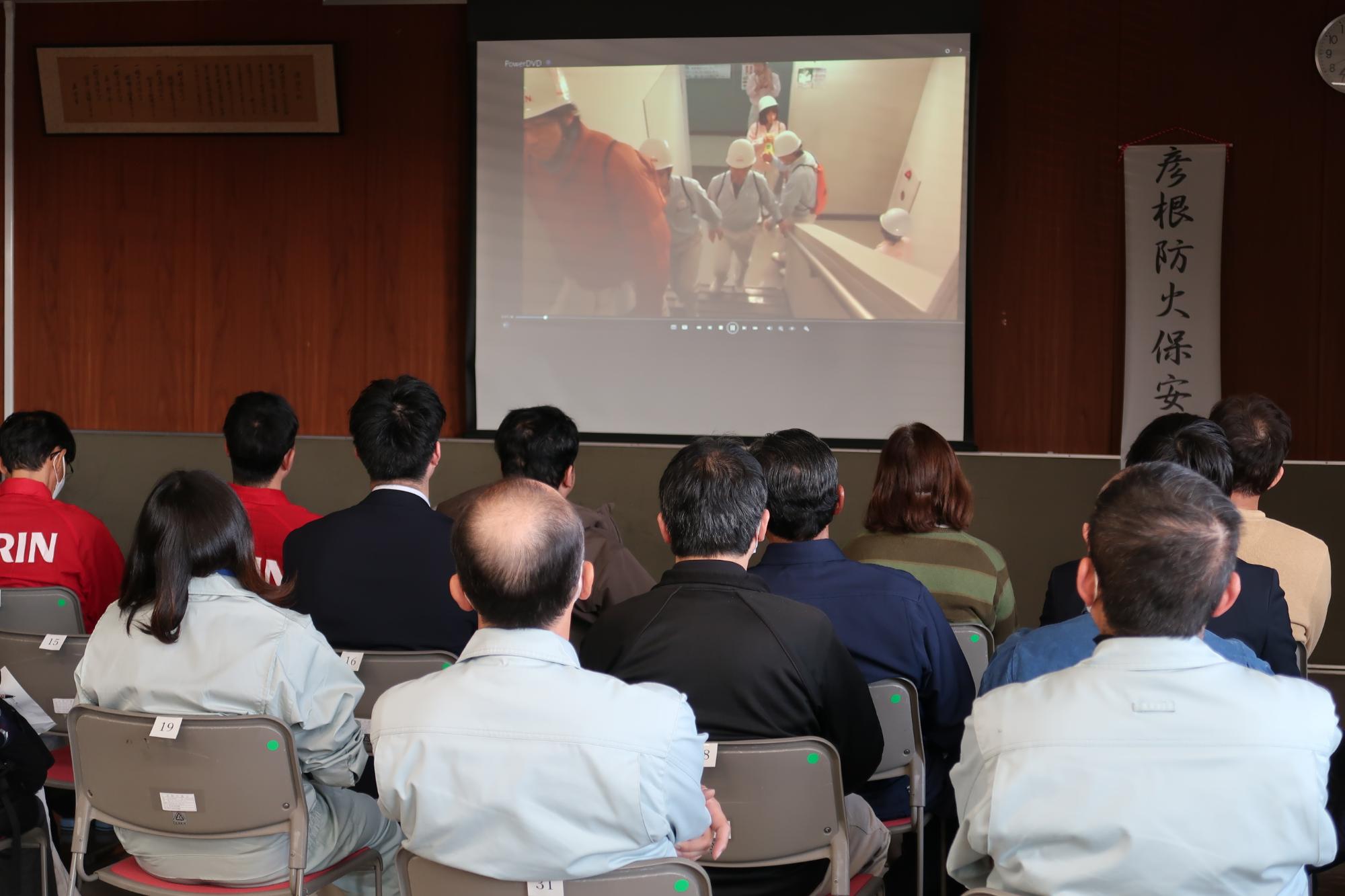 参加者が前方にあるスクリーンに映った映像を見ている様子