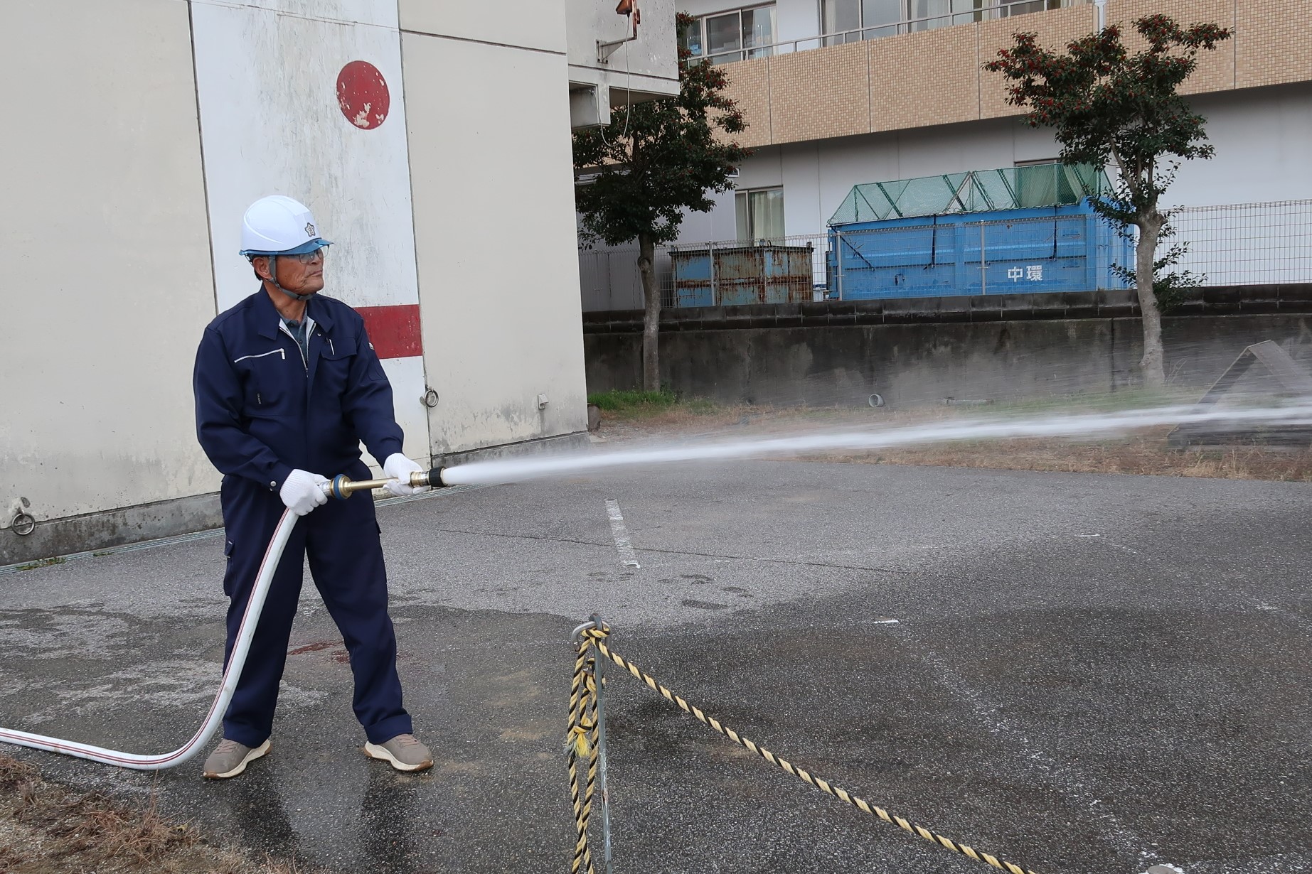 男性がホースを持ち放水している様子