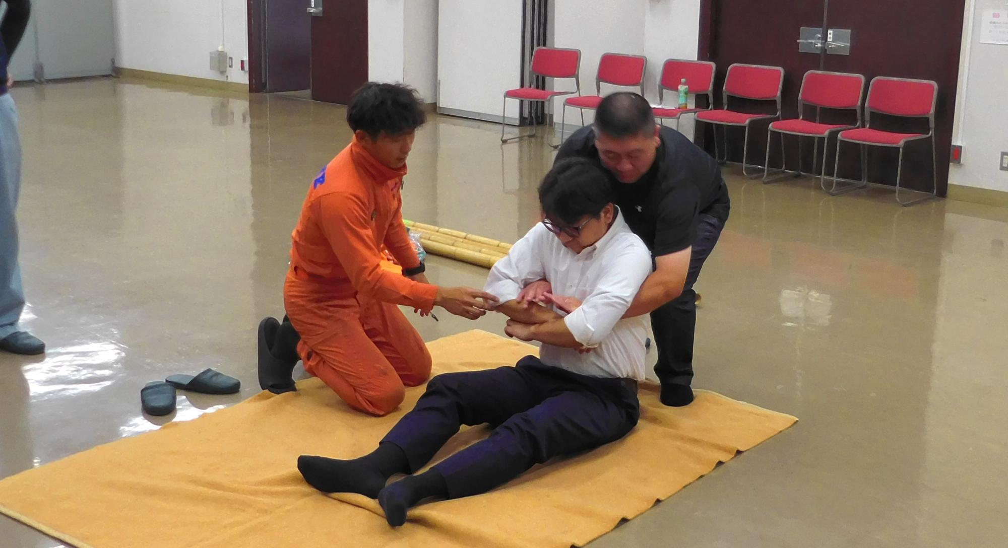 徒手搬送法を学ぶ受講者の写真