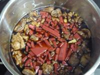鍋にすじ肉と赤こんにゃくと調味料を入れ強火で加熱している写真