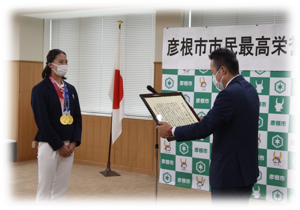 表彰状を読み上げる彦根市長と前に立つ大橋選手